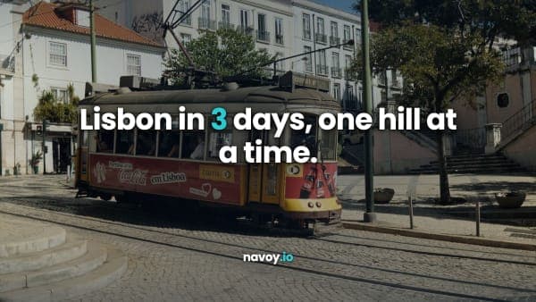 A classic yellow Lisbon tram on cobbled tracks in a sunlit street lined with trees and pale buildings